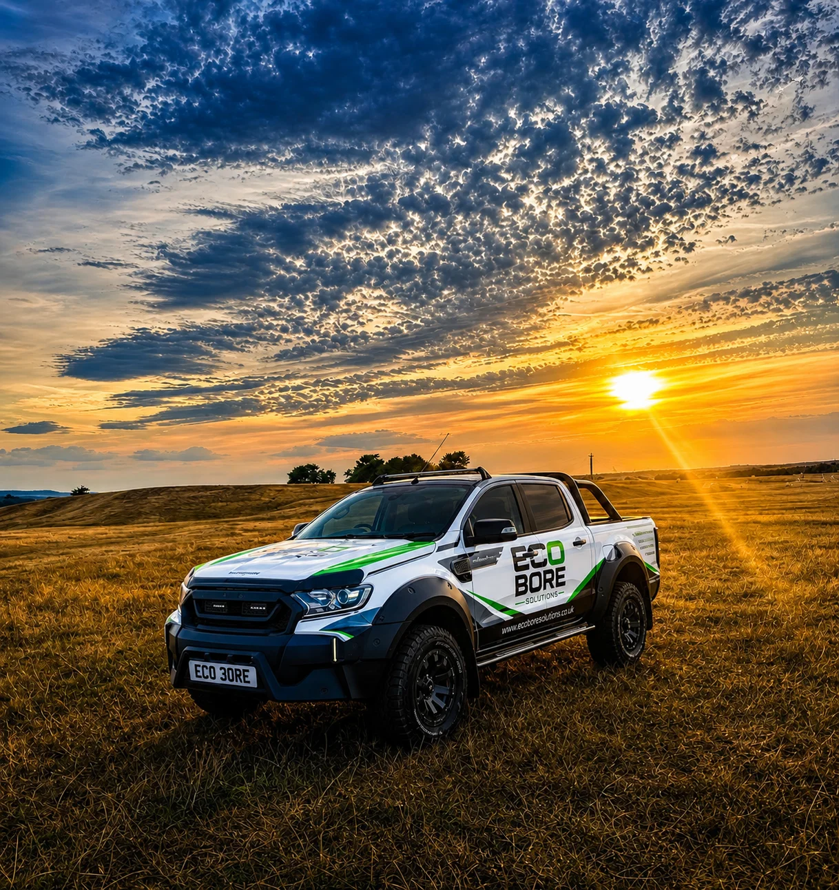 EcoBore Solutions liveried Ford Ranger drilling support vehicle parked in a field at sunset